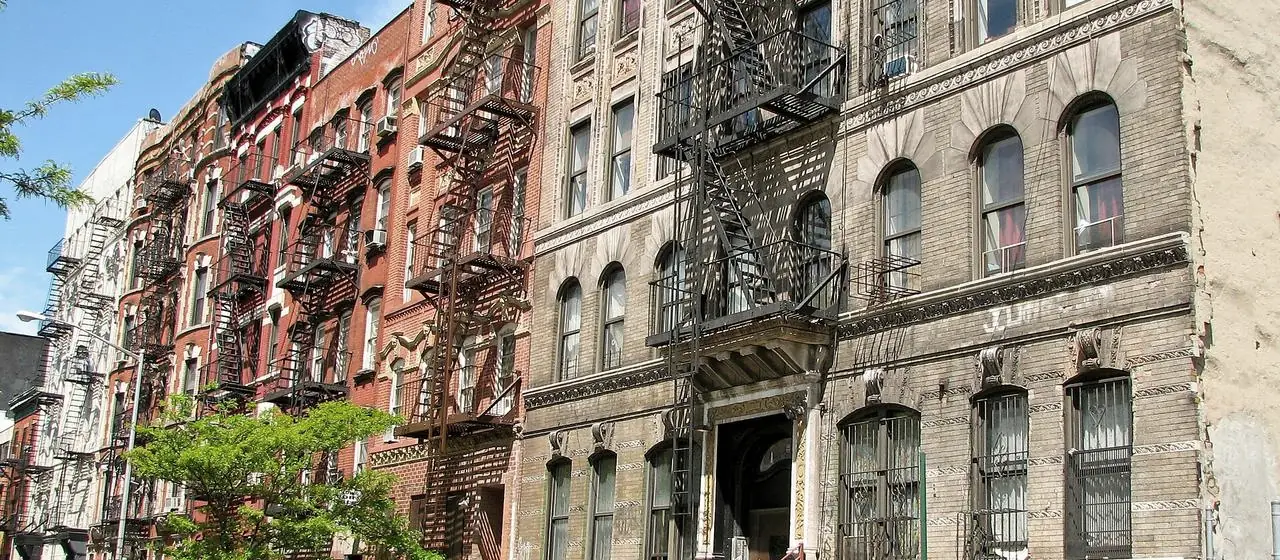 Tenement-era apartment buildings with iron fire escapes on a Lower Manhattan street