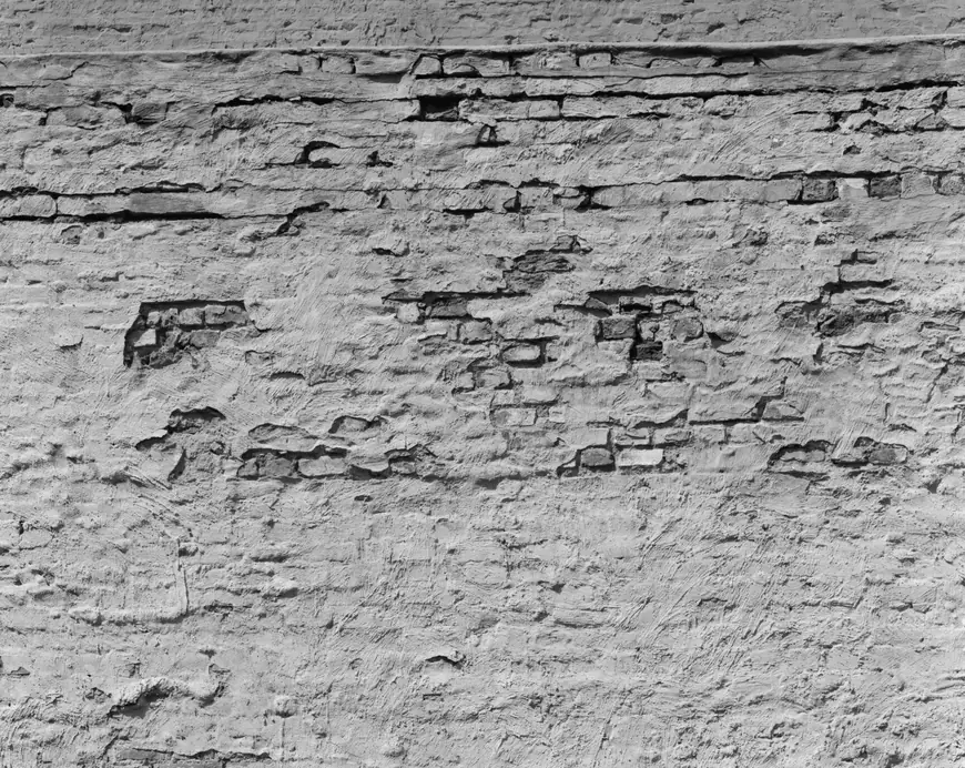 Spalled brick with missing faces and patched mortar on an old Manhattan wall